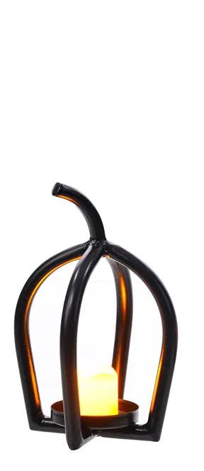 Metal black ribbed pumpkin candle holder with a glowing candle inside, available in two sizes.