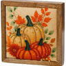 Beaded orange pumpkin block by Special T in a wooden frame, featuring two pumpkins with green stems and autumn leaves.