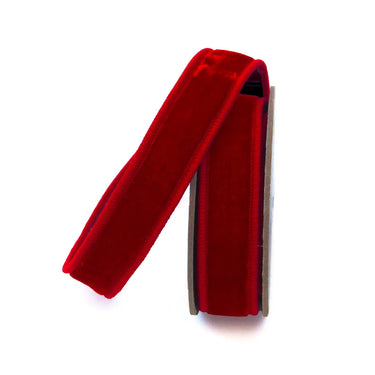 Red velvet ribbon on a wooden spool, close-up highlighting the soft velvet texture